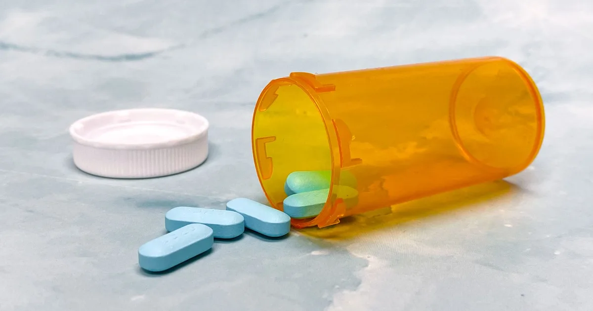 Flacon de médicaments renversé avec comprimés, symbole du régime de prévoyance CAVP