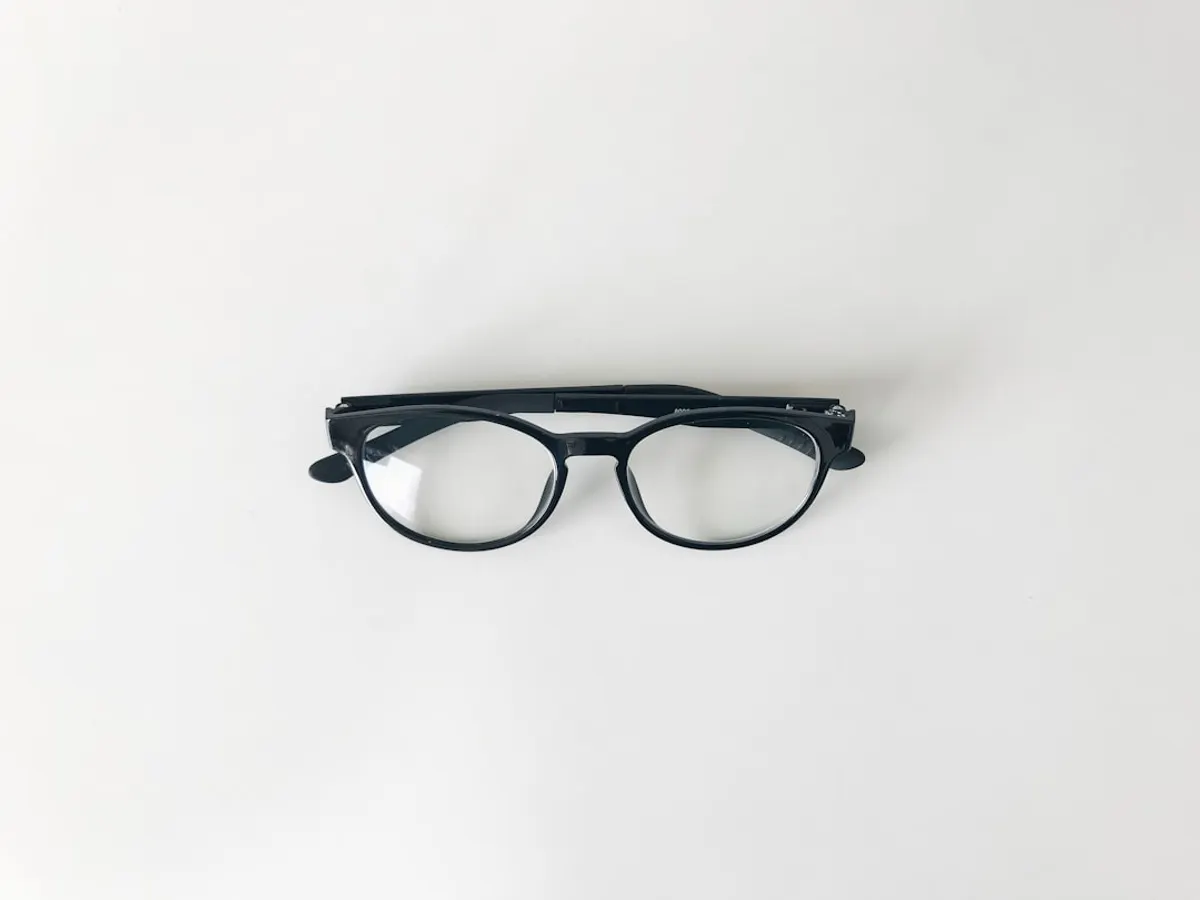 Lunettes de lecture posées sur des documents de complémentaire santé